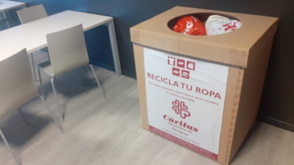 Imagen de una contenedor de papel de Cáritas presente en el interior de un edificio en zaragoza.